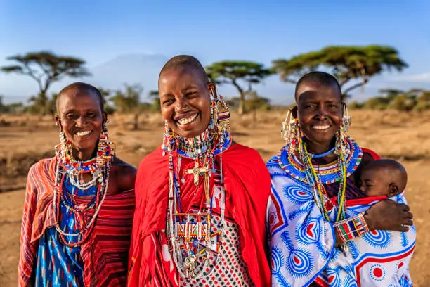Smiling Maasai women in traditional attire representing the communities we serve